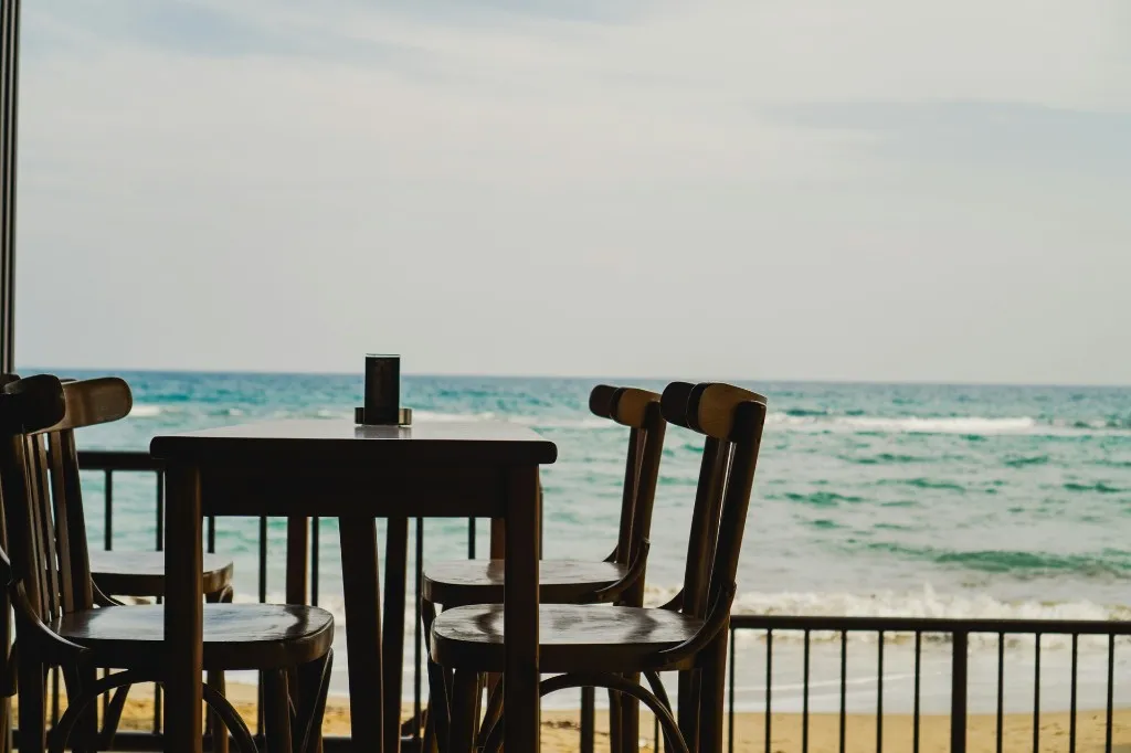 Outdoor restaurant table with sea view overlooking a turquoise bay